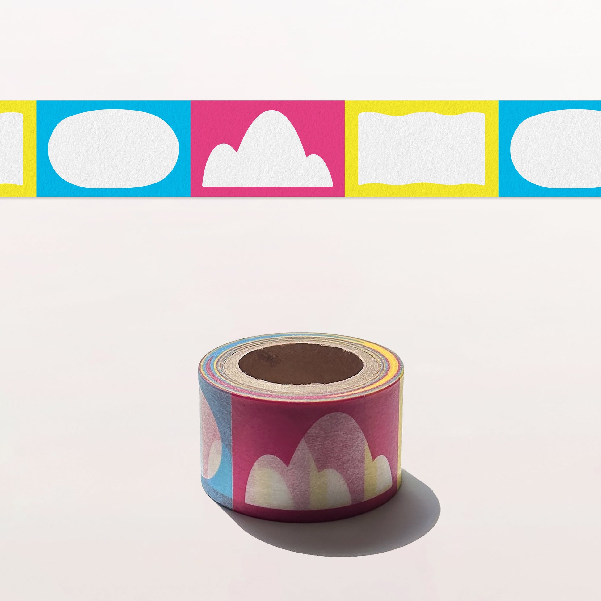 Roll of decorative tape with colorful cloud and square designs on a white background