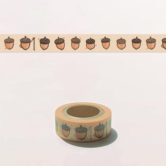 Roll of decorative tape with acorn pattern on a light background