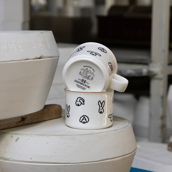 Set of ceramic mugs with rabbit design on a white surface