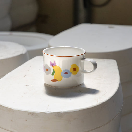 Ceramic mug with colorful design on a white surface