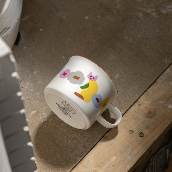 White mug with colorful designs on a wooden surface