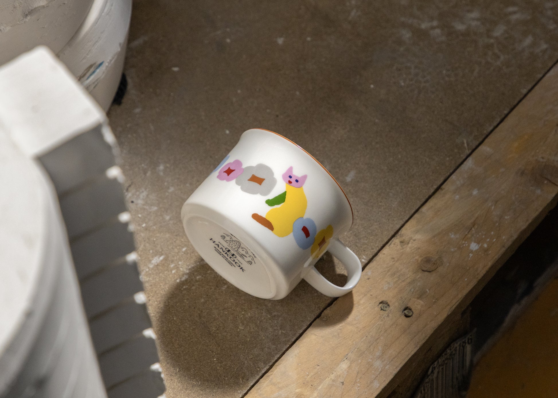White mug with colorful designs on a wooden surface
