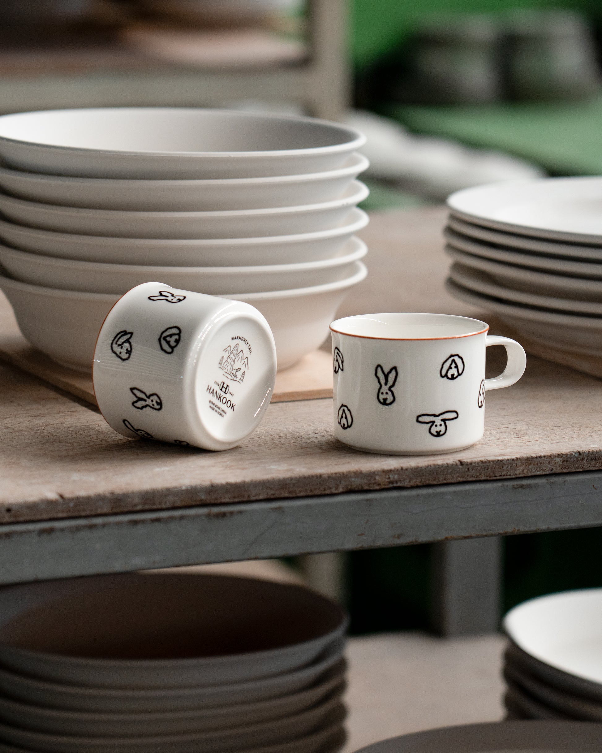 White ceramic mugs with black patterns on a wooden table