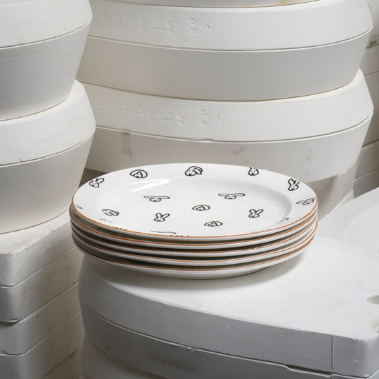 Stack of white ceramic plates with decorative patterns on a white background