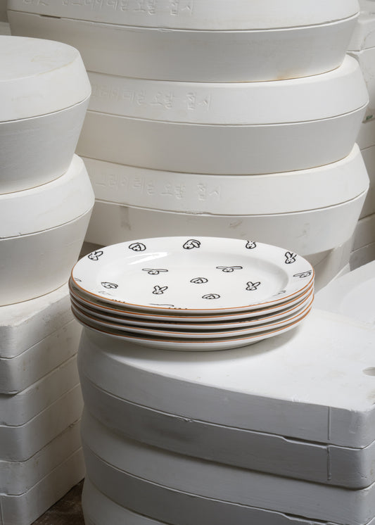 Stack of white ceramic plates with decorative patterns on a white background