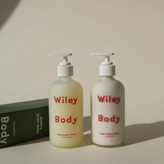 Two bottles of Wiley Body products on a neutral background