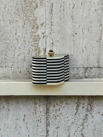 Small striped bag on a textured concrete surface