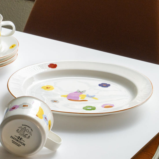 Decorative plate and mug with colorful designs on a white surface.