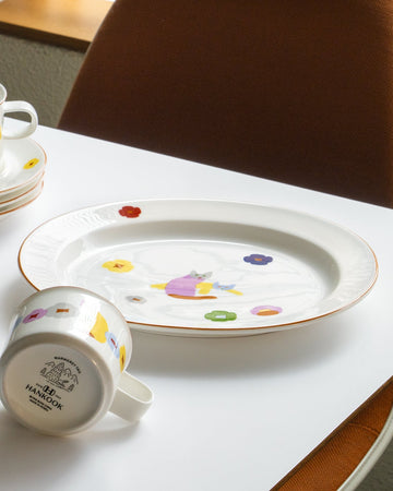 Decorative plate and mug with colorful designs on a white surface.