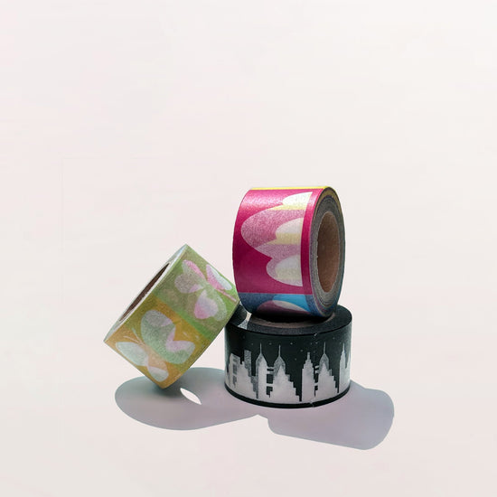 Three rolls of decorative tape with different designs on a white background