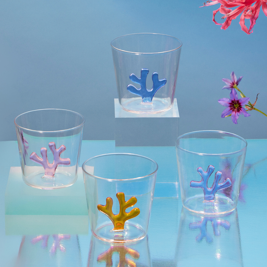 Clear glasses with coral-shaped inside on a blue surface with flowers.