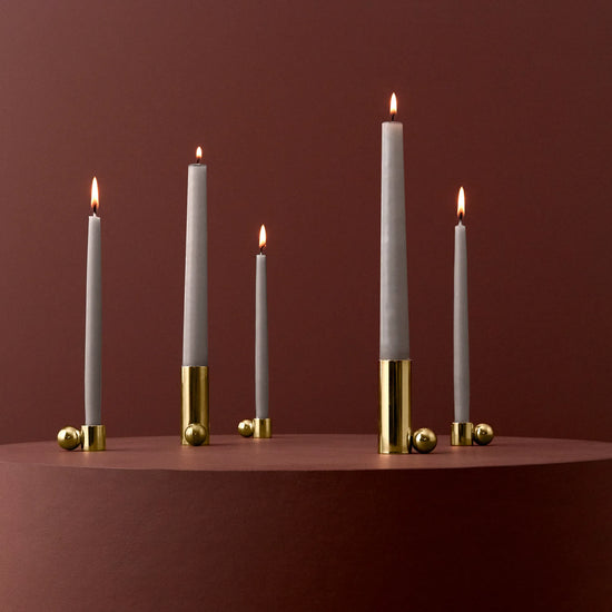 Set of candles with gold candle holder on a red background