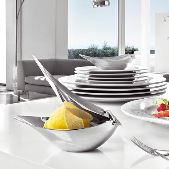 Modern kitchen with white countertops, plates, and a view of the outdoors.