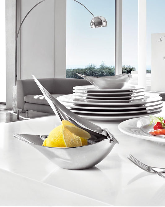 Modern kitchen with white countertops, plates, and a view of the outdoors.