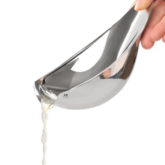 Metallic ladle pouring liquid on a white background