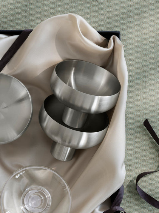 Coupe With Pedestal Stem on a beige fabric with a black box against a light green background