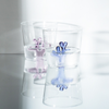 Two clear glass tumblers with pink and blue coral design inside on a reflective surface.
