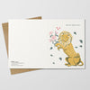 Greeting card with a lion holding flowers on a white background