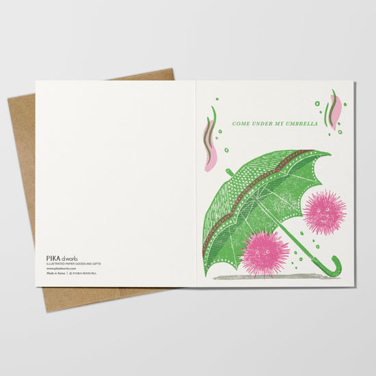 Greeting card with green umbrella on a white background