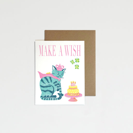 Greeting card with a cat and cake illustration and 'Make a Wish' text, on a white background.