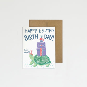 Greeting card with turtle and gift illustration and 'Happy Belated Birthday!' text on a white background