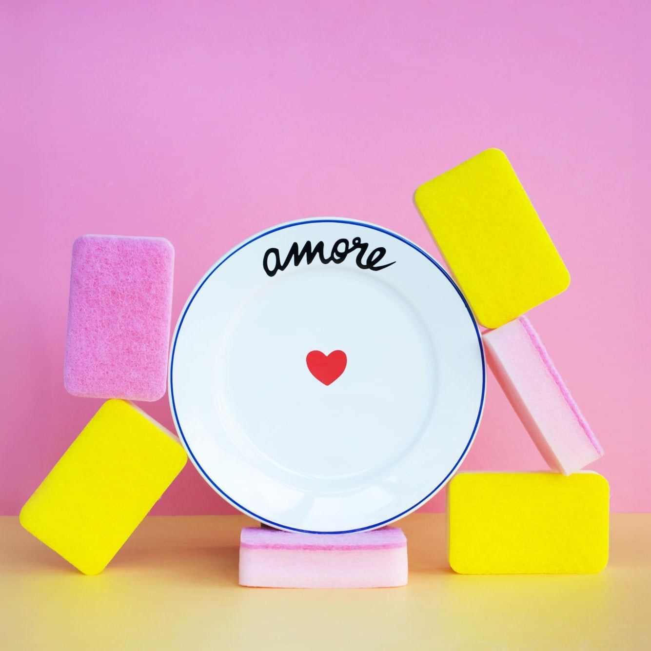 Decorative plate with 'amore' and a heart on a pink background