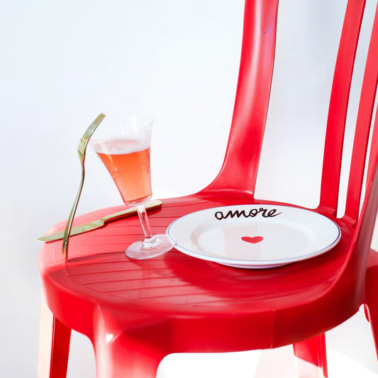 Red chair with a plate and glass on a white background