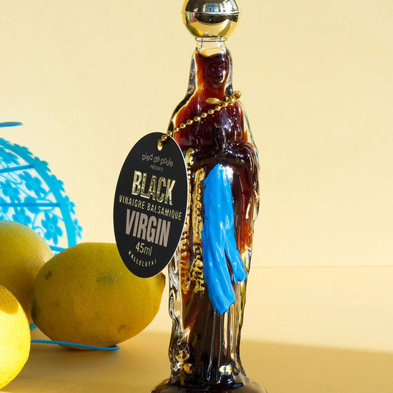 Bottle of Black Virgin rum with lemons and a blue basket on a beige background