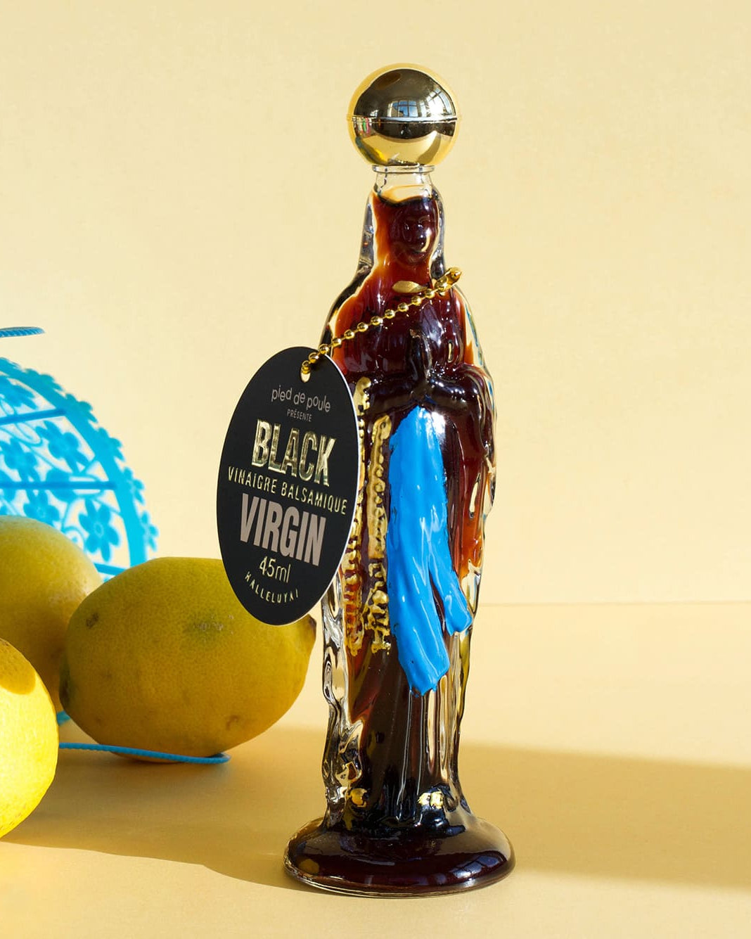 Bottle of Black Virgin rum with lemons and a blue basket on a beige background