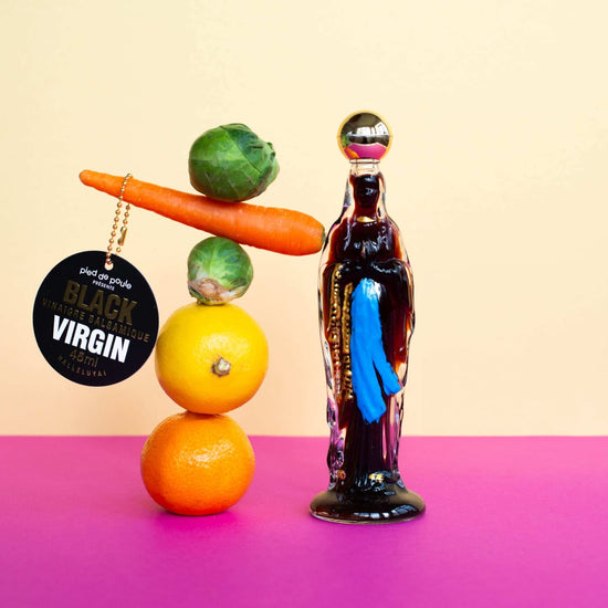 Bottle labeled 'Black Virgin' next to a pyramid of fruits on a gradient background