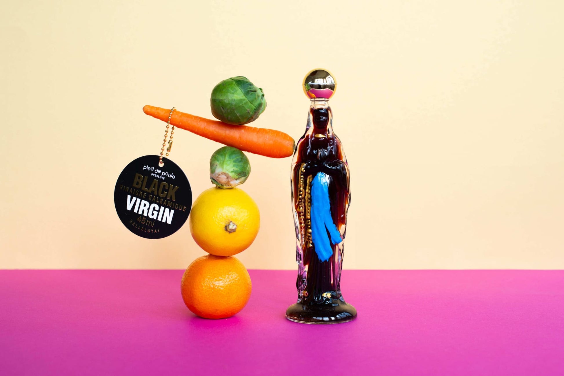 Bottle labeled 'Black Virgin' next to a pyramid of fruits on a gradient background
