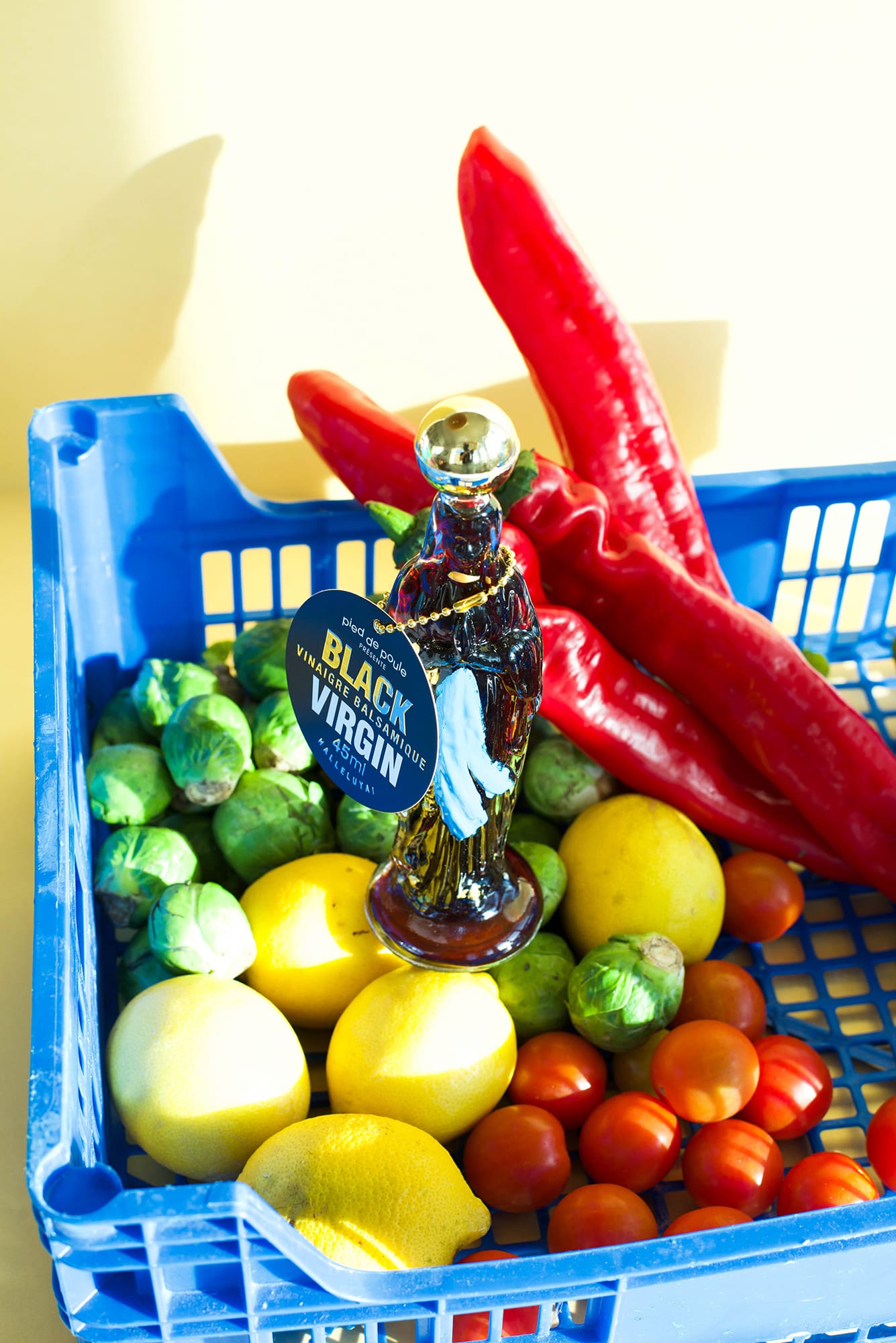 Basket of fresh produce with a bottle labeled 'Black Virgin' on a white background