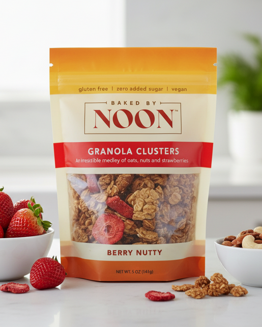 Packaging of Baked by Noon granola clusters with a berry nutty flavor on a white background.