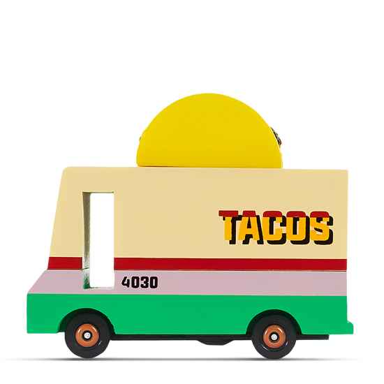 Colorful wooden toy taco truck with a yellow taco on top and the word ‘TACOS’ printed on the side in bold lettering.