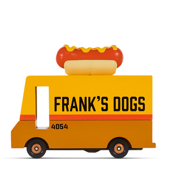 Yellow wooden hot dog truck with the text ‘FRANK’S DOGS’ on the side and a plastic hot dog decoration on the roof.