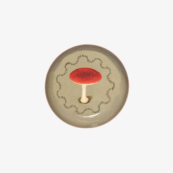 Ceramic plate with a red mushroom design on a white background