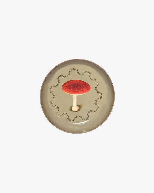 Ceramic plate with a red mushroom design on a white background