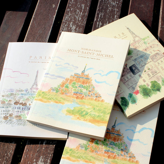 Three illustrated books on a wooden surface
