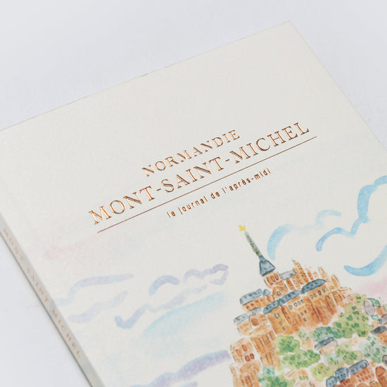 Book with illustration of Mont-Saint-Michel on a light background