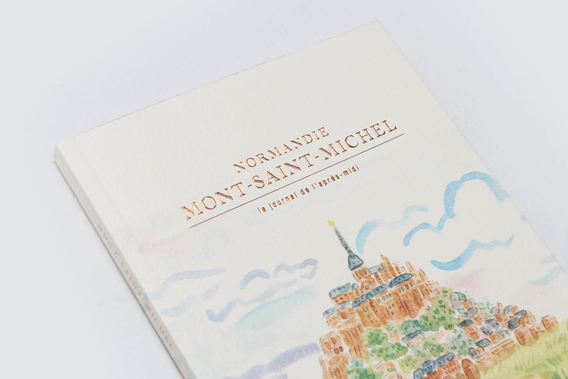 Book with illustration of Mont-Saint-Michel on a light background