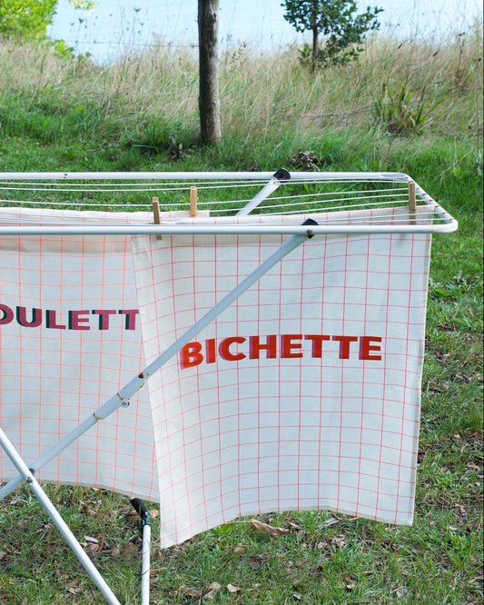 Portable washing line with 'Poulett Bichette' branding in an outdoor setting.