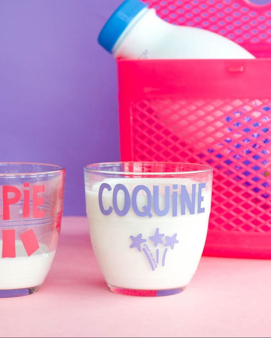 Two cups labeled 'CHIPIE' and 'COQUINE' with a pink container on a purple background.