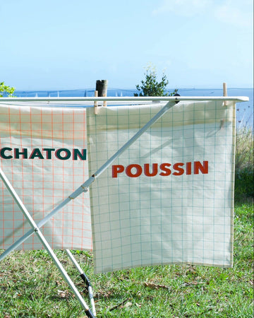 Fencing with signs labeled 'CHATON' and 'POUSSIN' in an outdoor setting.