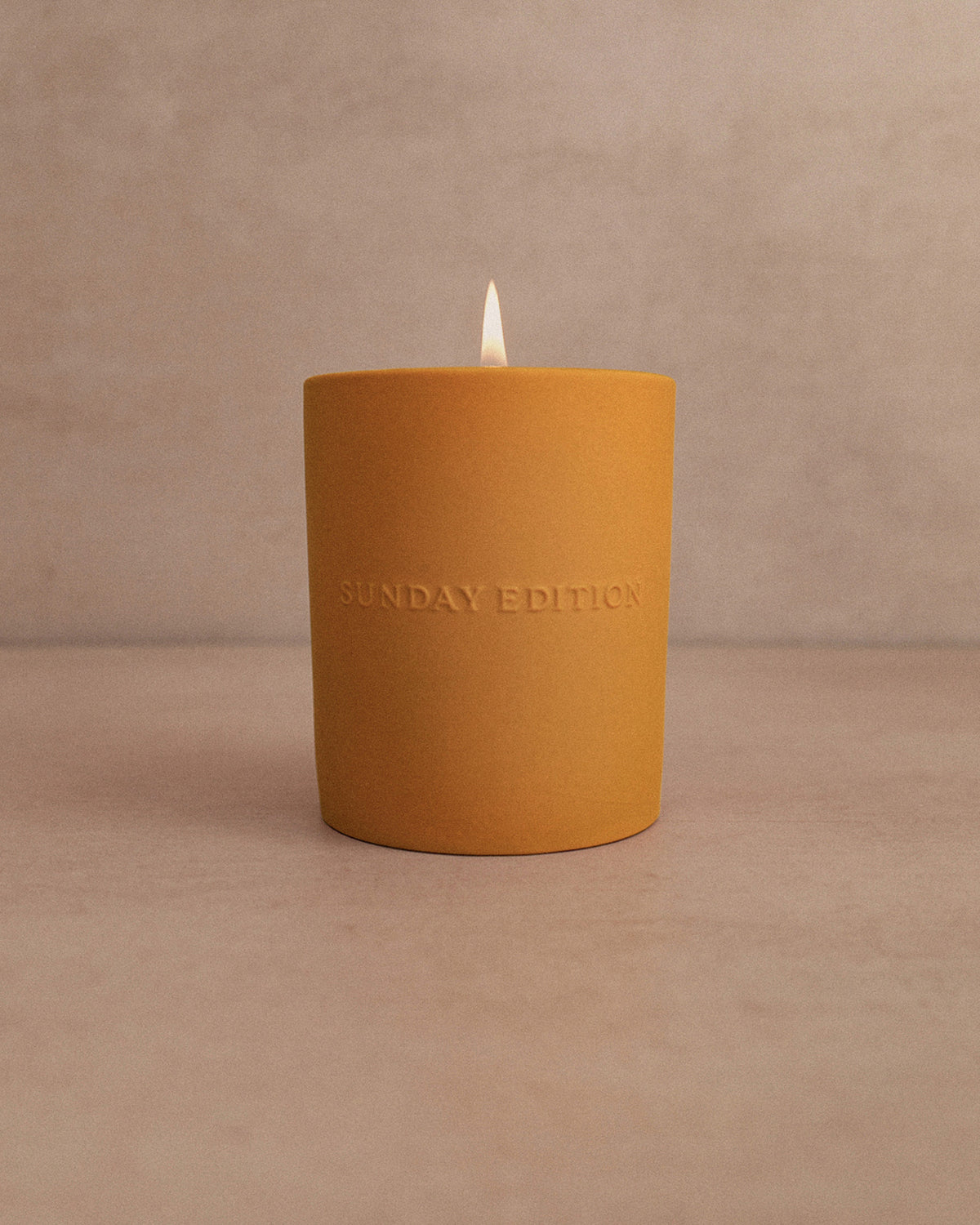 Yellow candle with 'Sunday Edition' branding on a beige background
