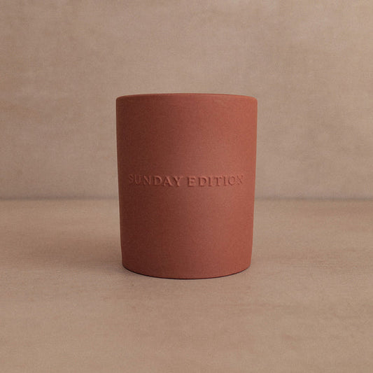 Red cylindrical container with 'SUNDAY EDITION' text on a beige background