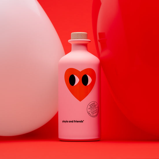 pink extra virgin olive oil bottle with heart in red background