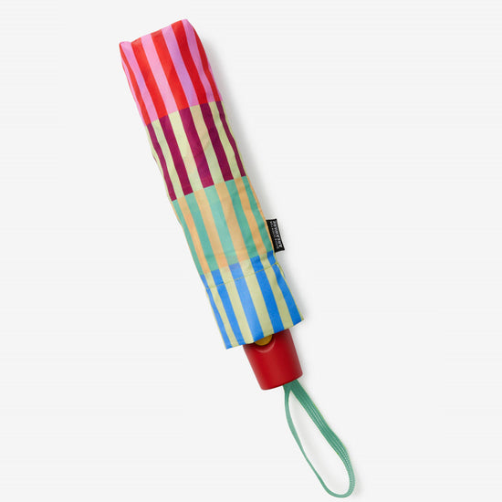 Colorful striped umbrella with a red handle on a white background