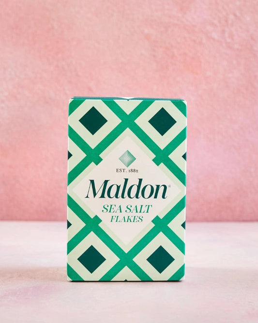 Maldon sea salt flakes packaging with geometric design on a pink background