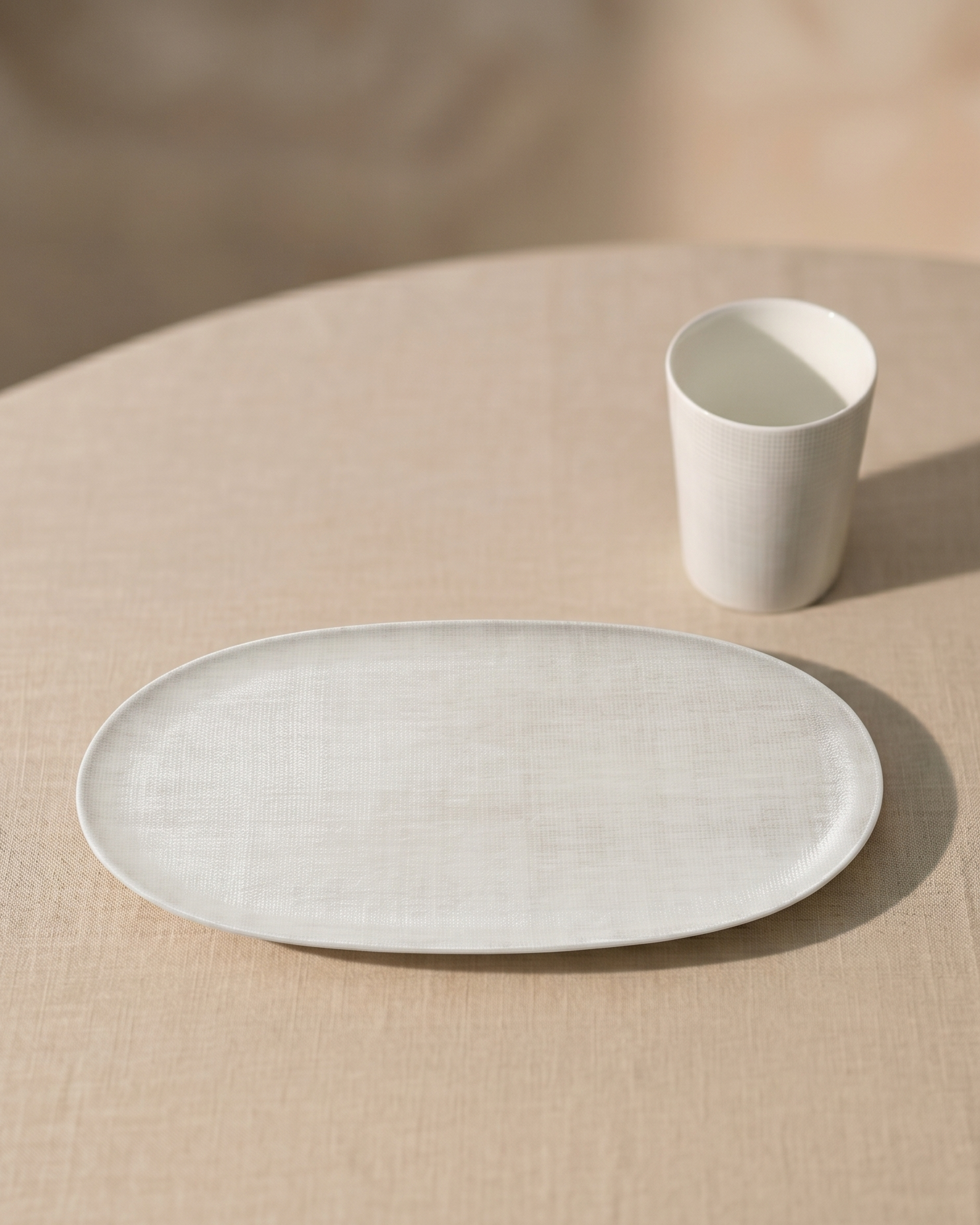 Ceramic plate and cup on a beige tablecloth