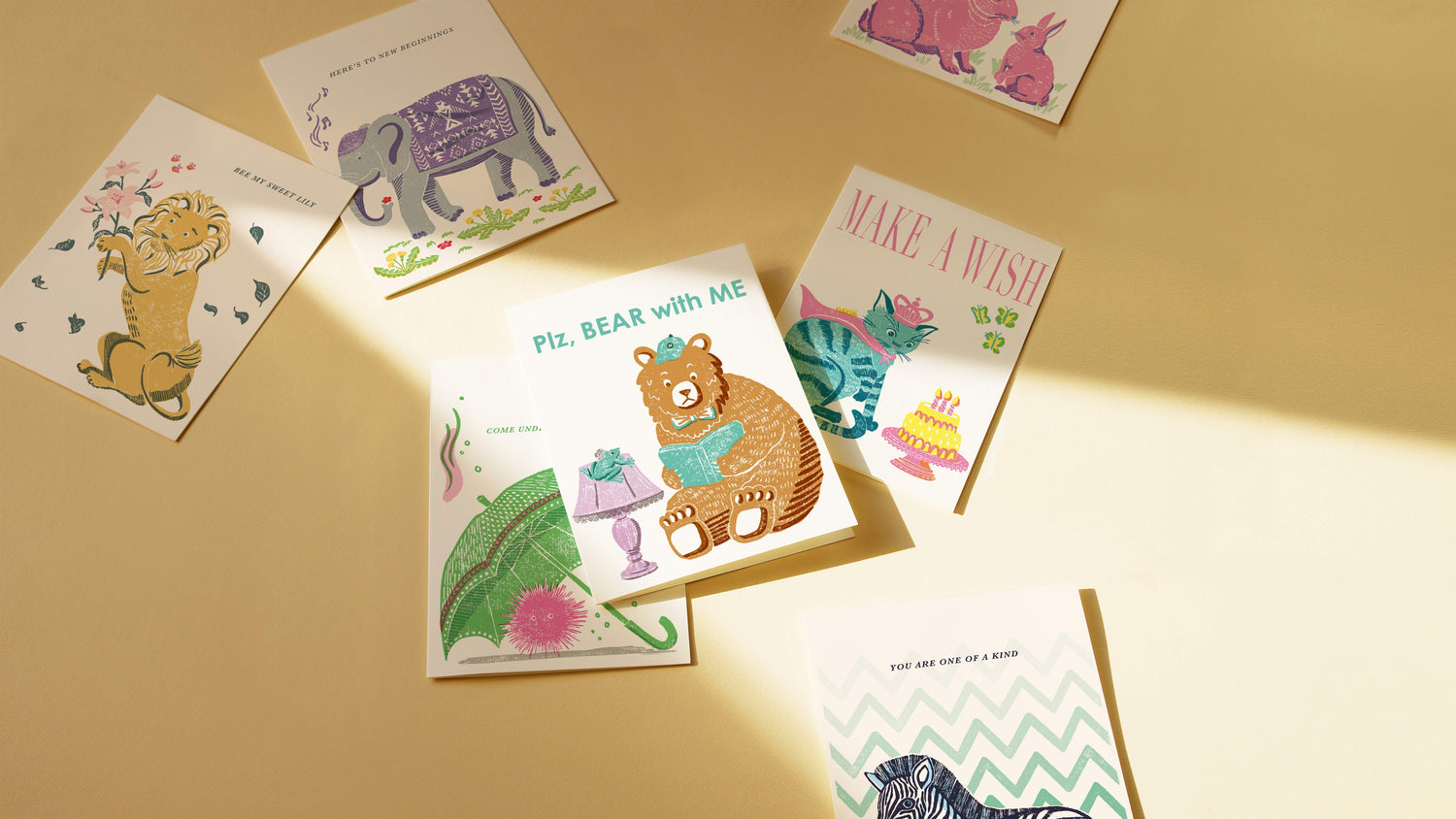 Collection of colorful children's greeting cards on a beige surface